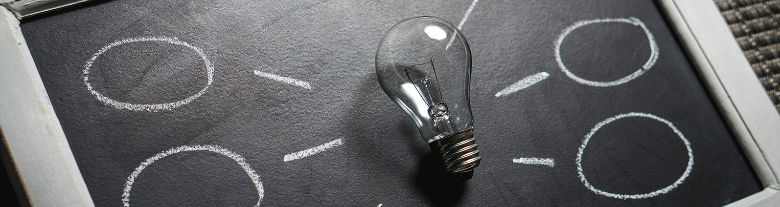 Light bulb on a chalkboard with empty speech bubbles